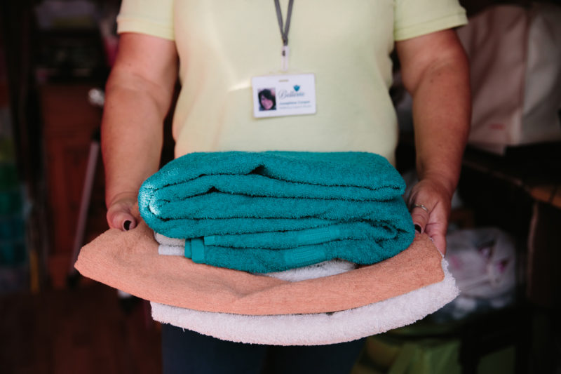 Wellbeing worker holding clean and folded clothes