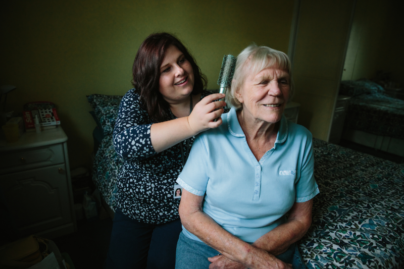 Well being support worker brushing Joan's hair